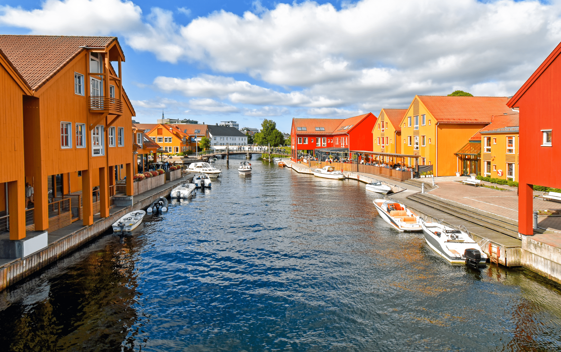 Fargerike bygninger på hver side av en kanal i Kristiansand.