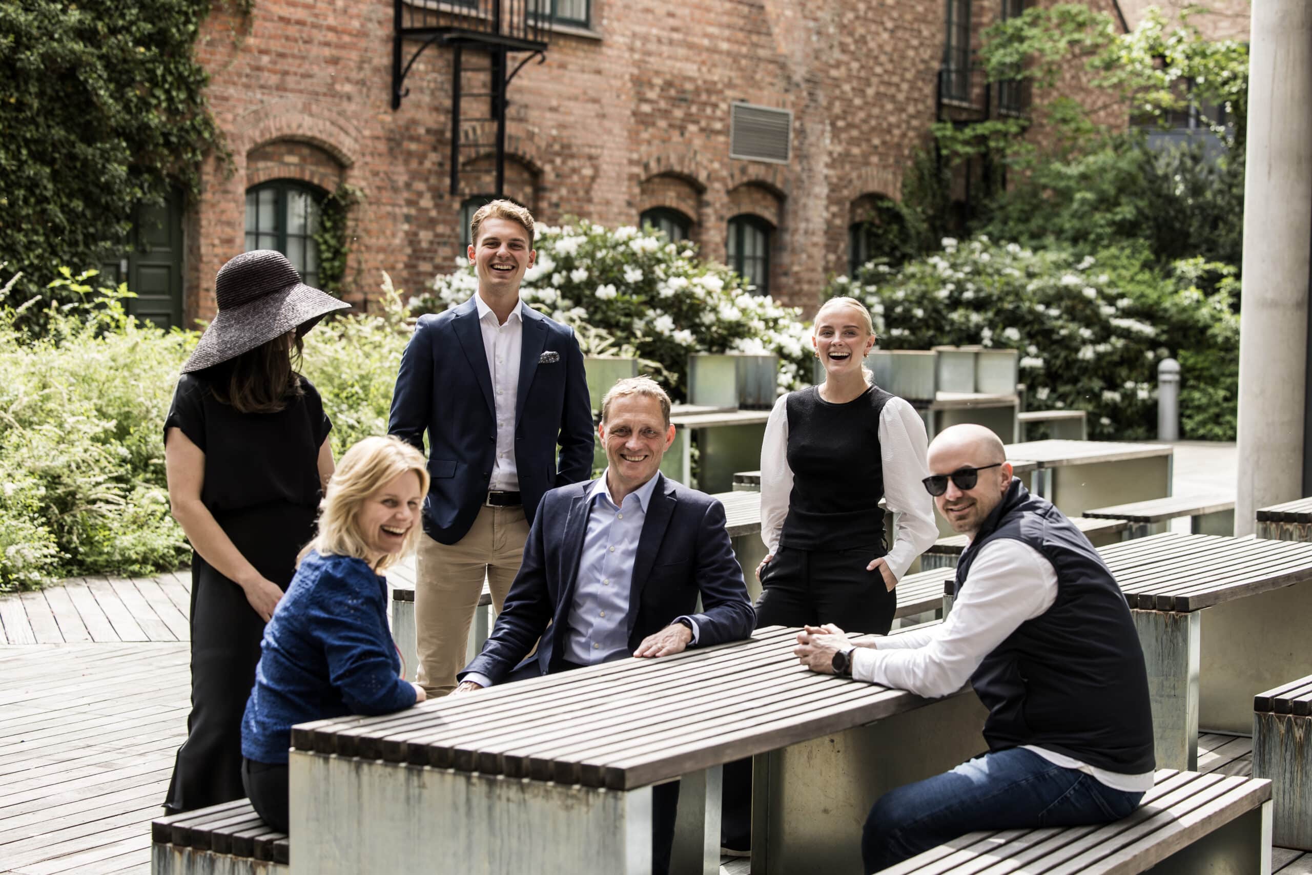En gruppe mennesker utendørs rundt et bord.